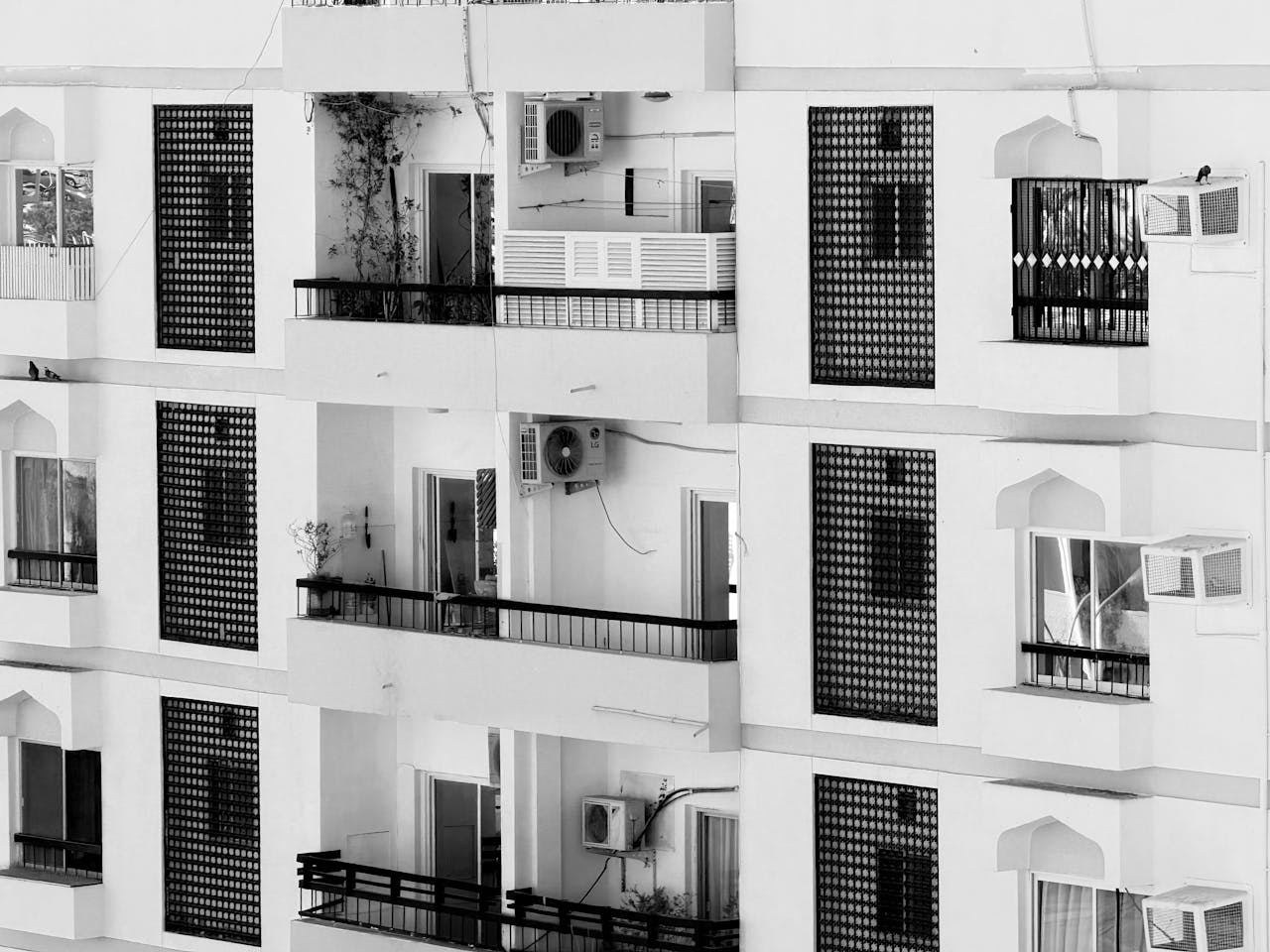 Monochrome photo of architectural apartment building facade with geometric balconies.